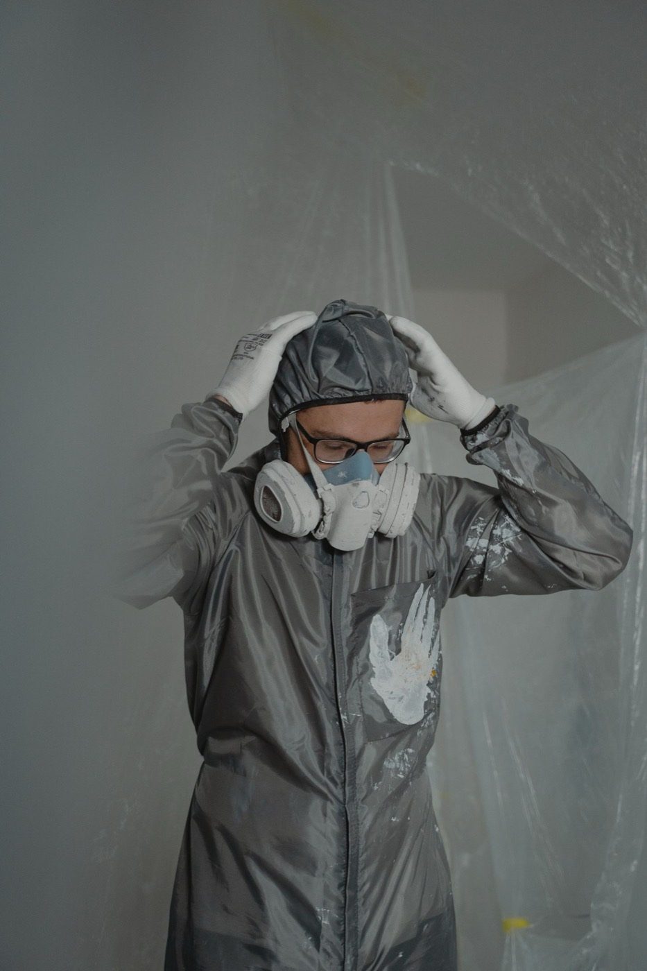 Remediation technician in protective suit inside a contained room